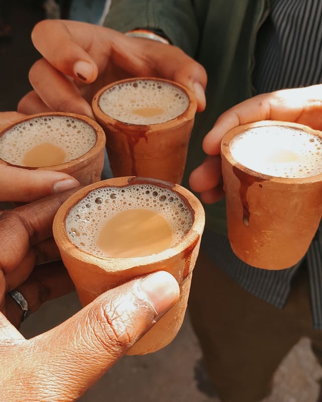 Friends raising kulhads of masala chai